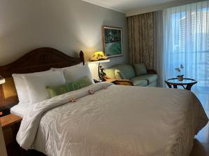 a bedroom with a large white bed and a couch at Aloha Gem Studio - 2 bed with high speed WIFI - Luana Waikiki Hotel & Suite 917, 2045 Kalakaua Avenue HI 96815 in Honolulu