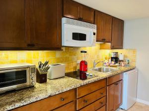 a kitchen with a sink and a microwave at Aloha Gem Studio - 2 bed with high speed WIFI - Luana Waikiki Hotel & Suite 917, 2045 Kalakaua Avenue HI 96815 in Honolulu