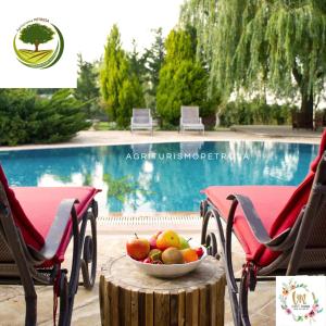 - un bol de fruits sur une table à côté de la piscine dans l'établissement Agriturismo Petrosa, à Castrovillari