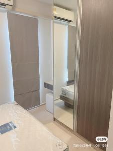 a bathroom with a mirror and a bed in a room at unio72 in Ban Khlong Samrong
