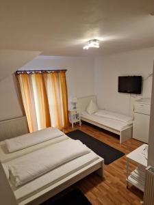 a room with two beds and a flat screen tv at Pensiunea Terra in Păcăleşti