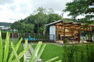 a small house in a garden with a patio at Innbox - Porto Belo in Porto Belo