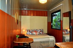 a bedroom with a bed and a table and a window at Innbox - Porto Belo in Porto Belo +26 photos