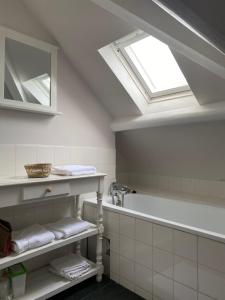 uma casa de banho com uma banheira e uma clarabóia em appartement Dinard hyper centre plage de l'Ecluse em Dinard