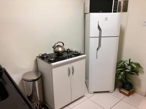 uma cozinha com um frigorífico e uma chaleira no fogão em Duplex do Largo em Curitiba