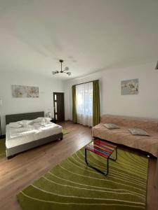 sala de estar con 2 camas y alfombra verde en Pensiunea Joker, en Sighişoara