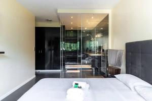 - une chambre avec un lit blanc et un mur en verre dans l'établissement HSH Lamballe-Passy Magnifique Appartement 4P, à Paris