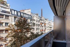 Elle offre une vue sur un grand bâtiment blanc depuis son balcon. dans l'établissement HSH Lamballe-Passy Magnifique Appartement 4P, à Paris