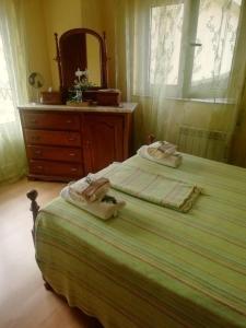 a bedroom with two beds and a dresser and a mirror at Alojamento Local Casa Veras in Vila Real