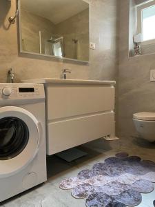 ein Badezimmer mit einer Waschmaschine und einem Waschbecken in der Unterkunft Apartment Tina in Rogoznica