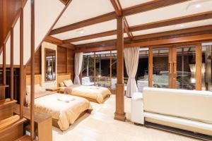 2 łóżka w pokoju ze szklanymi ścianami w obiekcie Sienna Resort w mieście Maratua Atoll