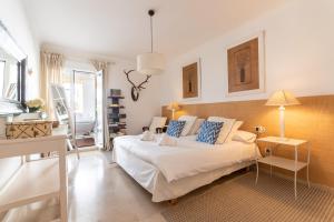 sypialnia z białym łóżkiem z niebieskimi poduszkami w obiekcie Apartment, front line beach, in Las Arenas, Bahía de Marbella w Marbelli +37 zdjęć