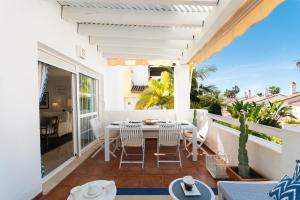 taras ze stołem i krzesłami na balkonie w obiekcie Apartment, front line beach, in Las Arenas, Bahía de Marbella w Marbelli