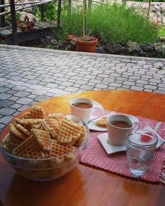 a table with a bowl of waffles and two cups of coffee at Zlatiborski Kutak in Zlatibor