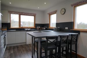 a kitchen with a table and some chairs in it at Maybank in Fort William