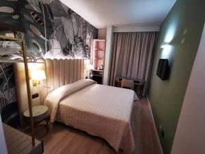 a small bedroom with a bed and a wall at Hotel Balcony in Florence