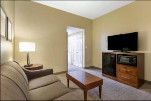 a living room with a couch and a flat screen tv at Comfort Inn & Suites Peachtree Corners in Norcross