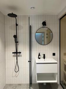uma casa de banho com um chuveiro, um lavatório e um espelho. em Fjällglim36 em Sälen