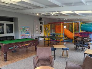 a room with ping pong tables and play equipment at Corriefodly Holiday Park in Blairgowrie