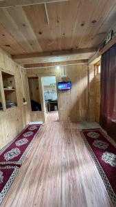 an empty room with wooden floors and a tv in a room at The Village View Homestay in Jibhi
