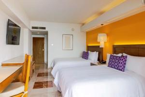 um quarto de hotel com duas camas e uma secretária em Camino Real Veracruz em Veracruz