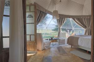 a bedroom with a bed and a large window at Ecoglamping Tafí del Valle in Tafí del Valle