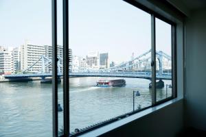 a view from a window of a river with a bridge at The Share Hotels Lyuro Tokyo Kiyosumi in Tokyo
