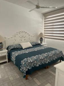 a bedroom with a bed with a blue comforter at Departamento familiar con vista al mar in Manzanillo