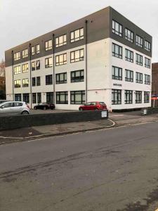 a large white building with cars parked in front of it at Cosy Apartment Haywards Heath in Haywards Heath