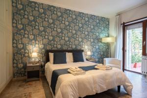 a bedroom with a bed with a blue and gold wallpaper at Room 66 in Naples