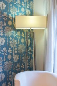 um candeeiro num quarto com papel de parede azul e branco em Room 66 em Nápoles