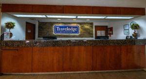 a hotel lobby with a large sign on the wall at Travelodge by Wyndham Pueblo in Pueblo