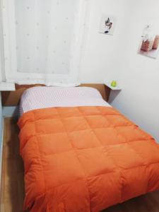 1 cama con edredón naranja en una habitación en Ca la Nuri Pis 2 con Vistas al Mar, en Llançà