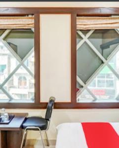 a bedroom with a desk and a chair and a window at Hotel Benaras Gharana Inn in Varanasi