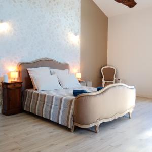 a bedroom with a large bed and a chair at Au repos des elfes in Braye-sous-Faye