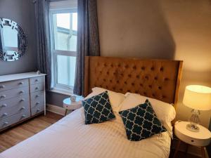 a bedroom with a bed with two pillows and a window at House near restaurants, park and pubs, perfect for pets! in Bristol