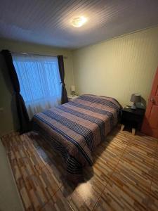 a bedroom with a bed and a window at Casa amoblada en Coronel in Concepción