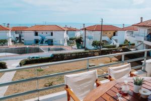 a balcony with a table and chairs and houses at Dimitra's Sunset View Apartment in Kalivia Poligirou