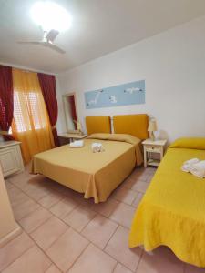 1 dormitorio con 2 camas con sábanas amarillas en A.I.R. Hotel Gabbiano, en Isola Rossa