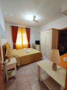 een hotelkamer met een bed en een bank bij A.I.R. Hotel Gabbiano in Isola Rossa