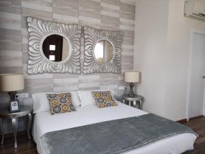 a bedroom with a large bed and two mirrors at Cal Music B&B in Premia de Dalt