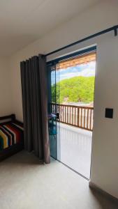 Vila Dos Diamantes - Lencois Bahia في لينكويس: غرفة مع باب زجاجي منزلق مع شرفة