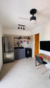 a kitchen with a stainless steel refrigerator and a table at Vila Dos Diamantes - Lencois Bahia in Lençóis