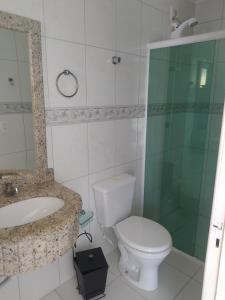 Un baño con inodoro, lavabo y ducha. en imóvel ideal para suas férias em Canto Grande, en Bombinhas