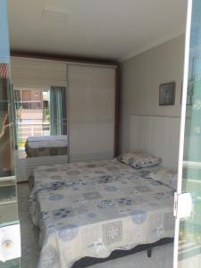 Un dormitorio con dos camas y un gran espejo. en imóvel ideal para suas férias em Canto Grande, en Bombinhas