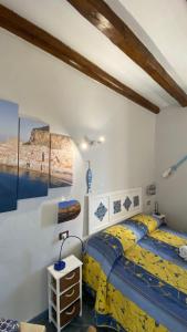 チェファルにあるDal Duomo al Mare Cefalùのベッドルーム1室(ベッド1台、テーブルの上にランプ付)