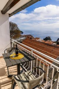 a table with two chairs and a bottle of wine on a balcony at Apartments Imperijal Dubrovnik in Dubrovnik