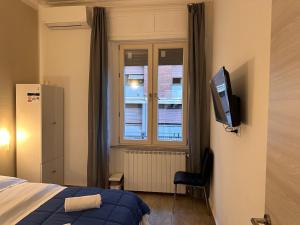 een slaapkamer met een bed en een televisie aan de muur bij Dream Guest House in Pisa