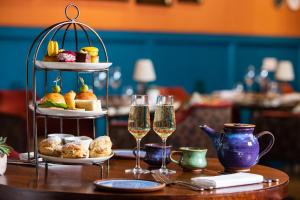 een tafel met twee glazen champagne en een dienblad met eten bij The Bird, Bath in Bath