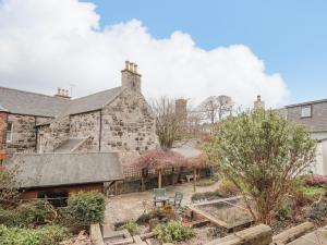 an old stone house with a garden in front of it at 20 South High Street in Portsoy